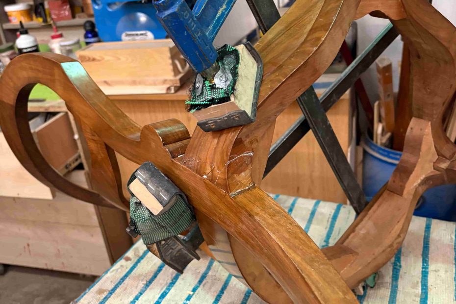 Proceso artesanal de encolado y reparación de silla de madera en Madrid